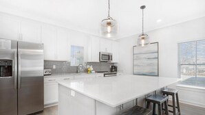 A modern kitchen with a large island, stainless steel appliances, and pendant lighting. - Hidden Gem! 3br/2.5ba Home/pool/near Beach/slps 10 (Orange Beach)
