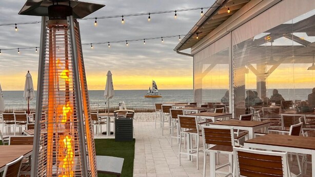 An outdoor dining area with tables and chairs, overlooking the ocean at sunset. - Hidden Gem! 3br/2.5ba Home/pool/near Beach/slps 10 (Orange Beach)