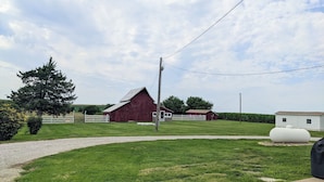A rural landscape with a red barn, a white building, and a large white tank. - Farmhouse on the Prairie - You can see for miles! (valley falls)