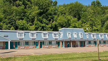 A motel with a row of rooms, each with a front porch and a brick facade.
