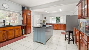 Una cocina amplia con armarios de madera, una isla central y un gran ventanal que proporciona luz natural.