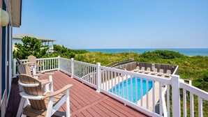 A wooden deck with a pool, white railings, and beach views. - Off Crew-Oceanfront, pool, hot tub, private walkway to the beach, game room, ocean views! (Corolla)