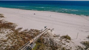A beach with a wooden boardwalk leading to the water, sandy dunes, and a clear view of the ocean. - Stunning Views, 3bd/2ba w/ Private Balcony (Orange Beach)