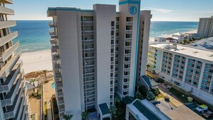 A high-rise hotel with multiple balconies, a beach view, and a parking area. - Stunning Views, 3bd/2ba w/ Private Balcony (Orange Beach)