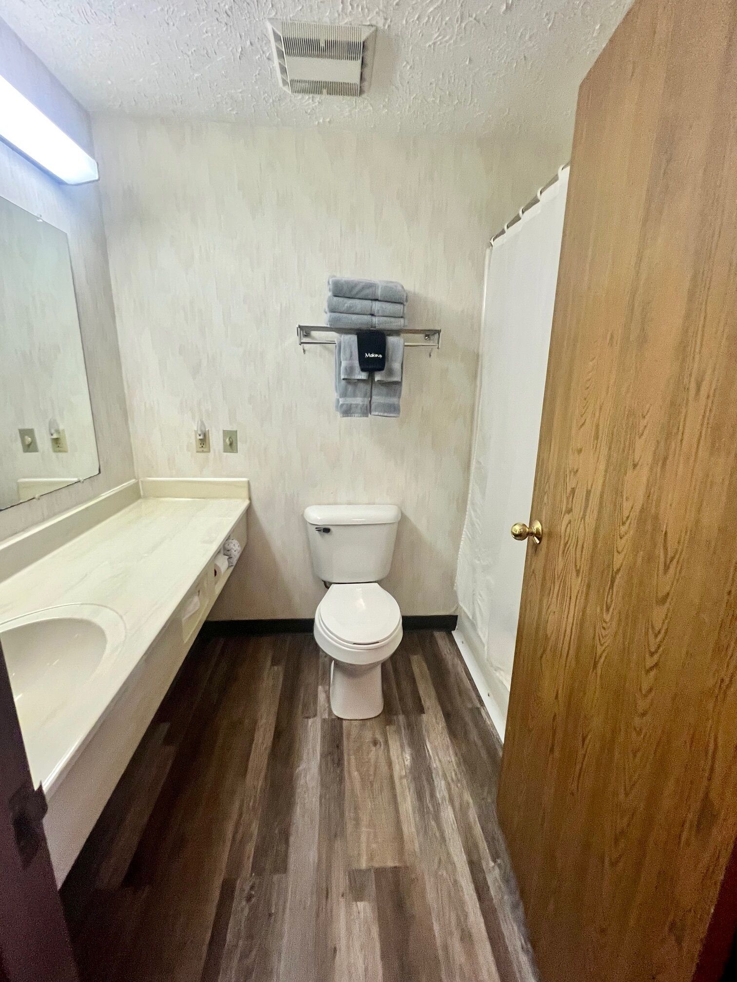 A small bathroom with a toilet, a sink, and a towel rack.