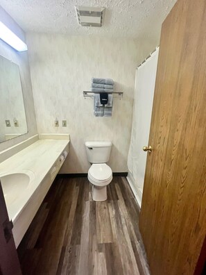 Een kleine badkamer met toilet, wastafel en handdoekhouder.