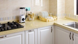 A kitchen with white cabinets, a countertop, a stove, a sink, and a window. - Luxurious 2BR Retreat with Upscale Touches and 24/7 Security (Nairobi)