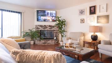 A living room with a fireplace, a television, and a comfortable seating area.
