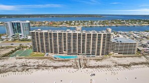 A large hotel with multiple floors, a swimming pool, and a beach area. - Beachfront Condo w/ View & Pool, Sleeps 8 (Orange Beach)