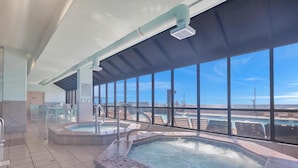 A rooftop pool area with two hot tubs, large windows, and a view of the ocean. - Beachfront Condo w/ View & Pool, Sleeps 8 (Orange Beach)