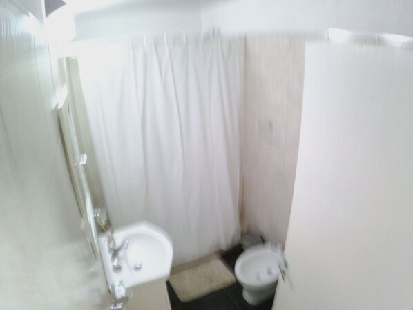 Un baño pequeño con lavamanos, inodoro y espejo.