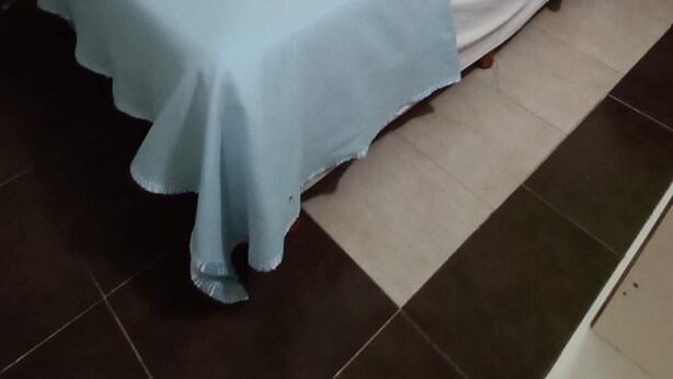 A bed with a white headboard and a blue bedspread in a room with green walls and a tiled floor. - Casa Mis Suegros (Mar del Plata)