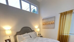 A bedroom with a large bed, two bedside tables with lamps, a window with curtains, and a wall-mounted artwork. - 2-bedroom vacation home just 6 minutes from SoFi Stadium (Los Angeles)