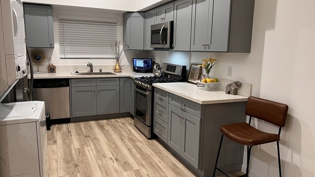A modern kitchen with grey cabinets, a built-in microwave, a stove, and a dishwasher. - 2-bedroom vacation home just 6 minutes from SoFi Stadium (Los Angeles)