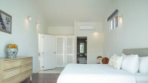 A bedroom with a large bed, a dresser, a wardrobe, and a bathroom visible through an open door. - Matuk 3 (Playa del Carmen)
