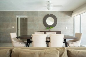 A modern dining area with a round table, six chairs, a decorative mirror, and a ceiling fan. - Matuk 3 (Playa del Carmen)