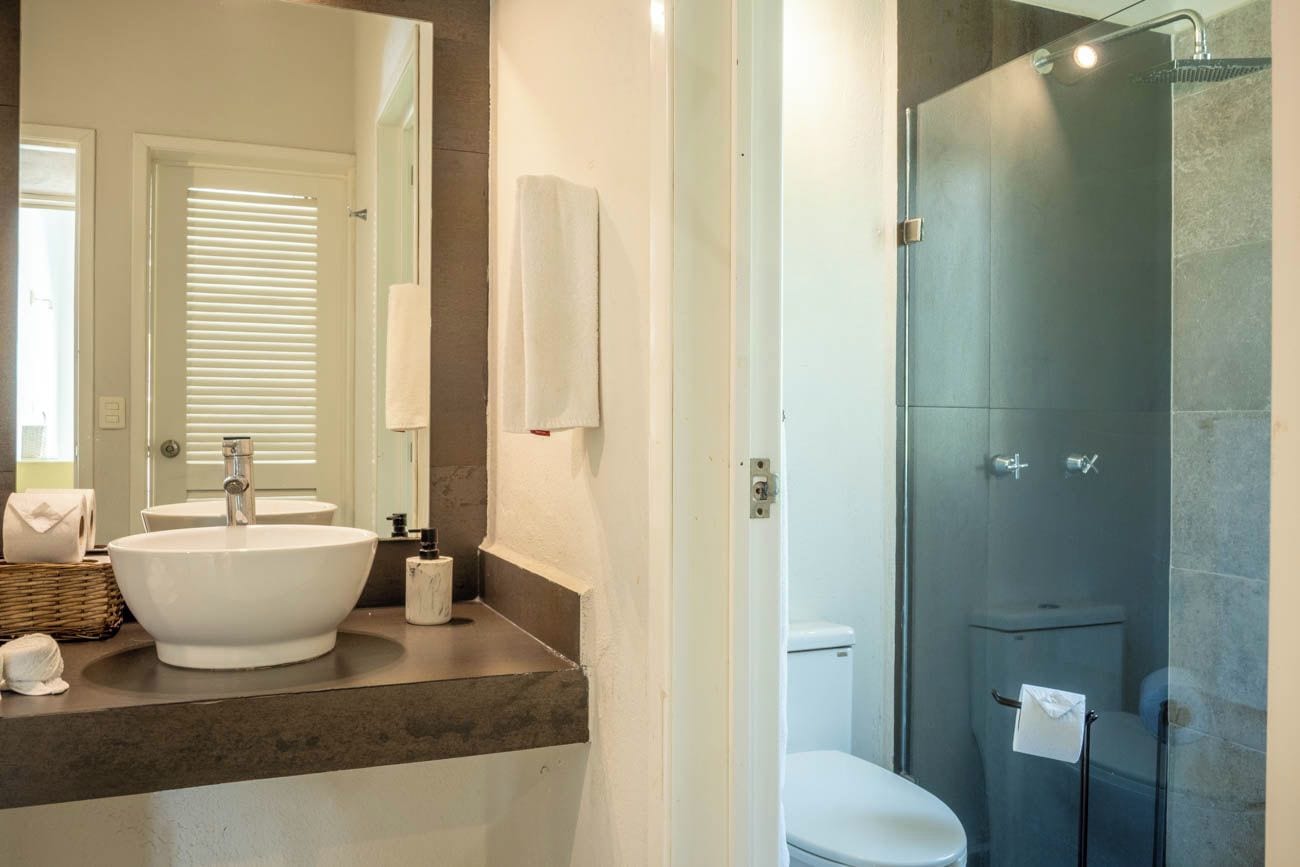 Une salle de bain moderne avec un grand lavabo blanc, une douche à parois de verre et des toilettes.