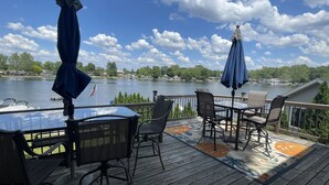 A deck with outdoor seating and a view of a lake. - Beautiful lakefront property with hot tub  (Leesburg)