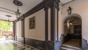 A hallway with checkered flooring, columns, and decorative lighting fixtures. - Maria s Bright Flat by Wonderful Italy - Duomo 2 (Naples)