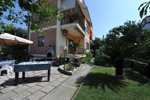 Ein Außenbereich mit Terrasse, einem Kicker, einer Bank und einem Tisch mit Stühlen.