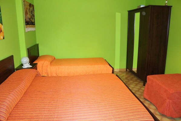 A room with two beds, a wardrobe, and a small table. - Orange Dreams in Sant Agnello (Sant'Agnello)