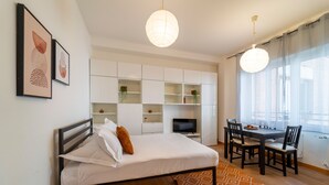 Un dormitorio moderno con cama, escritorio y televisor.