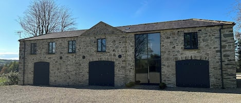 A stone building with two large garage doors and a large glass door.