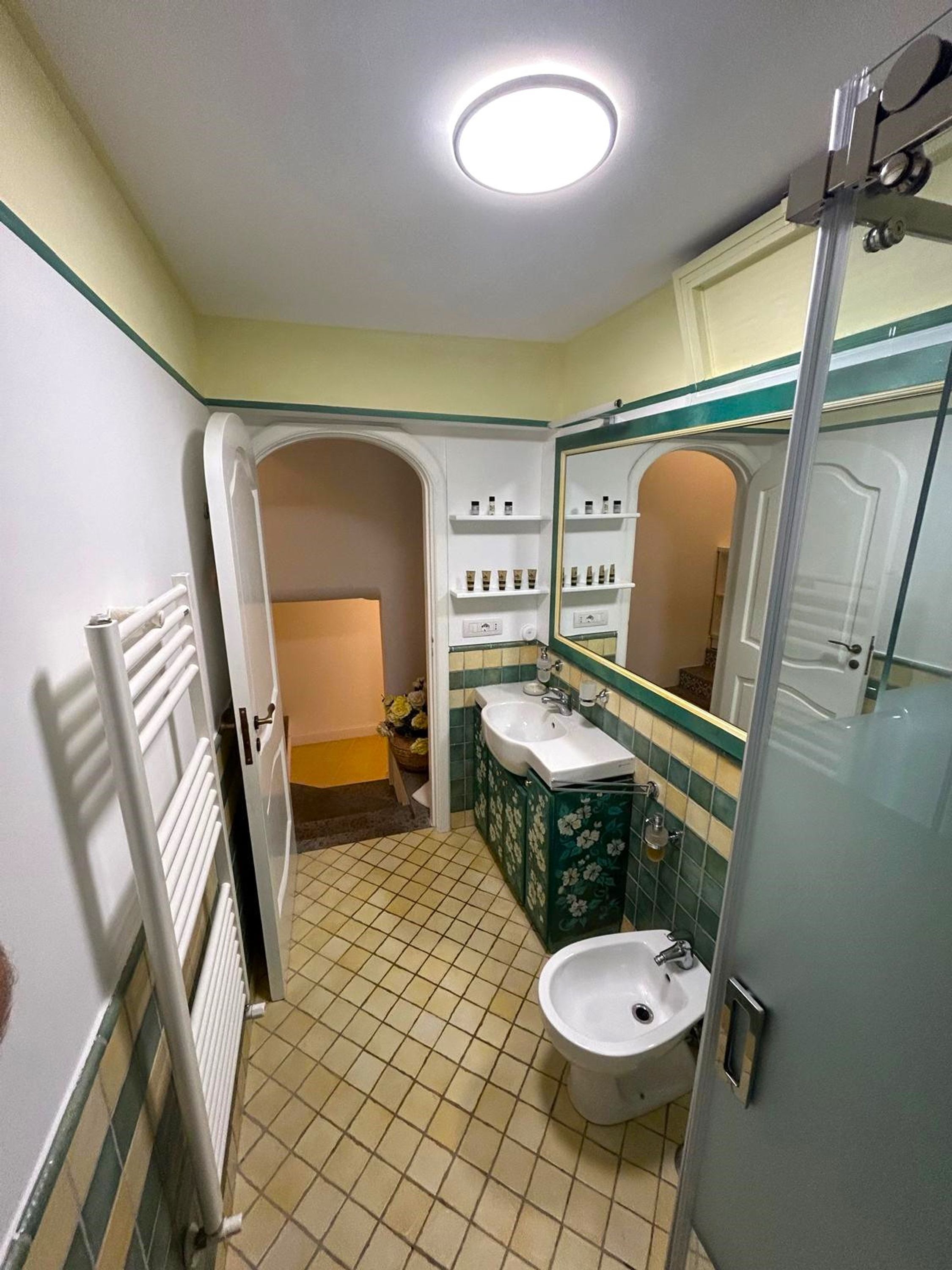 Un baño con un lavamanos blanco, un espejo y una ducha.