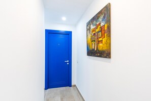 A hallway with a blue door and a painting on the wall. - Duomo Charme Studio by Wonderful Italy (Naples)