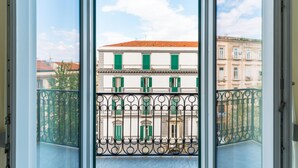 A balcony with a wrought iron railing and a view of a building with green shutters. - Duomo Charme Studio by Wonderful Italy (Naples)