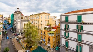 A street view of a city with buildings, a blue staircase, and a green car. - Duomo Charme Studio by Wonderful Italy (Naples)