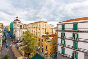 A street view of a city with buildings, a blue staircase, and a green car. - Duomo Charme Studio by Wonderful Italy (Naples)