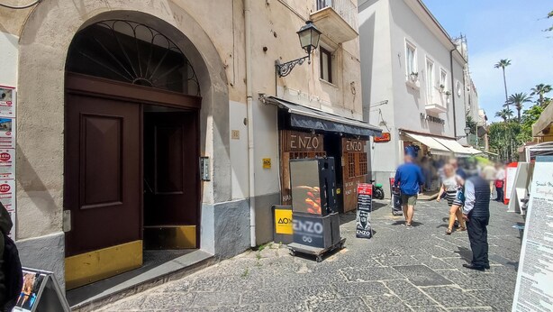 A street with a building featuring a large arched doorway and a storefront with signage. - Sorrento Hearts in Sorrento (Sorrento)