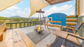 Relax by the fire pit on the outdoor deck, surrounded by comfortable seating and a scenic view.