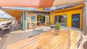 Enjoy dining al fresco under a spacious canopy with comfortable seating and lush greenery.