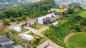 Un quartier résidentiel avec des maisons modernes, un camping-car blanc et un champ verdoyant.