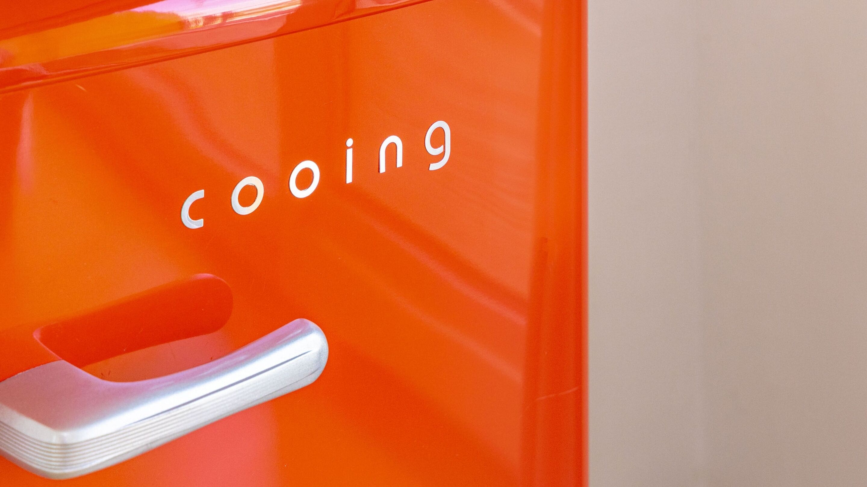 Primer plano de un electrodoméstico naranja, con la palabra "cooling" visible.