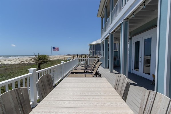 Relax on the covered porch with outdoor seating and enjoy unobstructed ocean views.