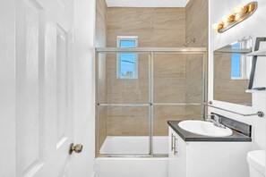 Departamento básico, 1 cama Queen size y sofá cama | Baño | Regadera, jabón, shampoo, papel de baño 