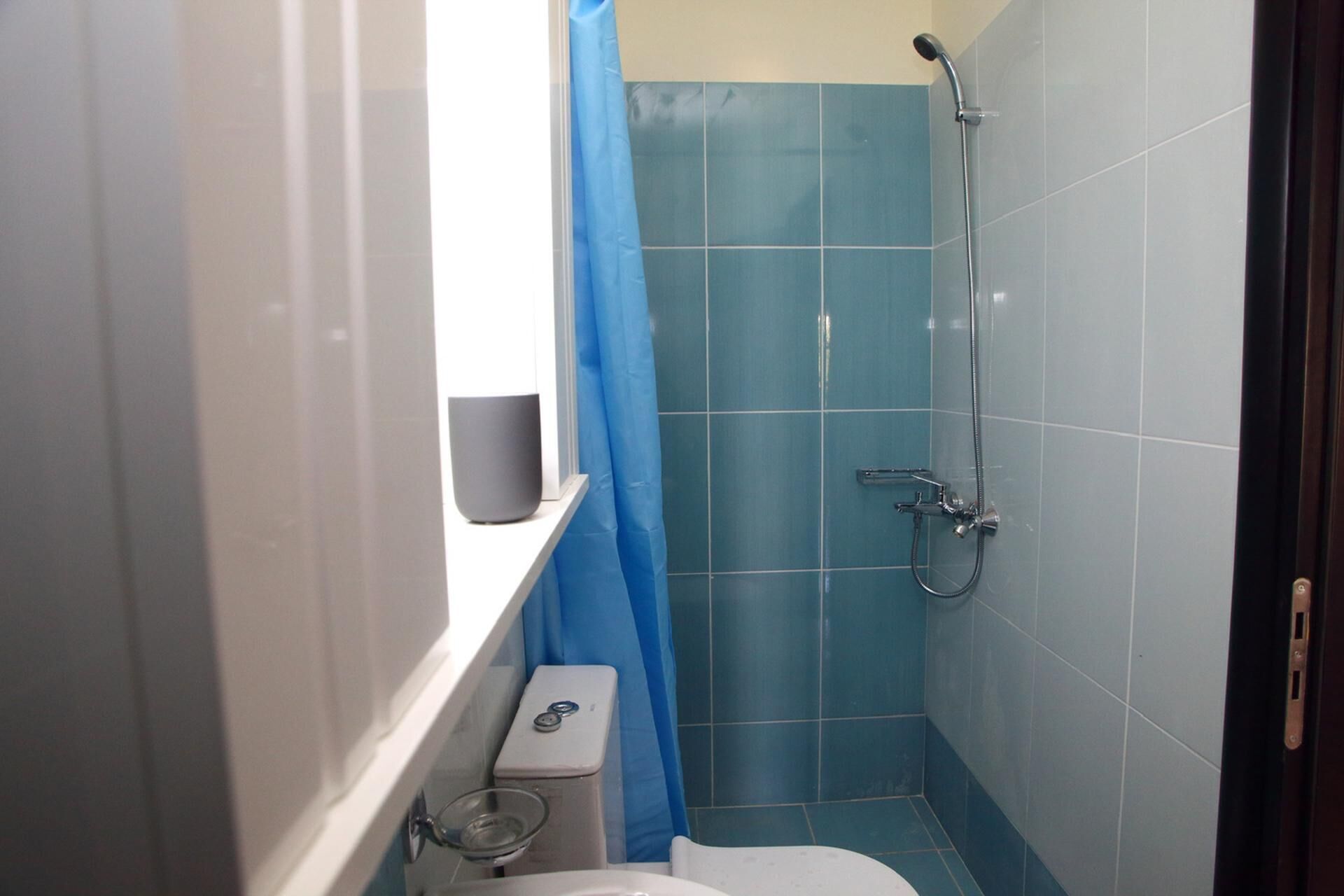 A small bathroom with a shower, a toilet, and a sink.
