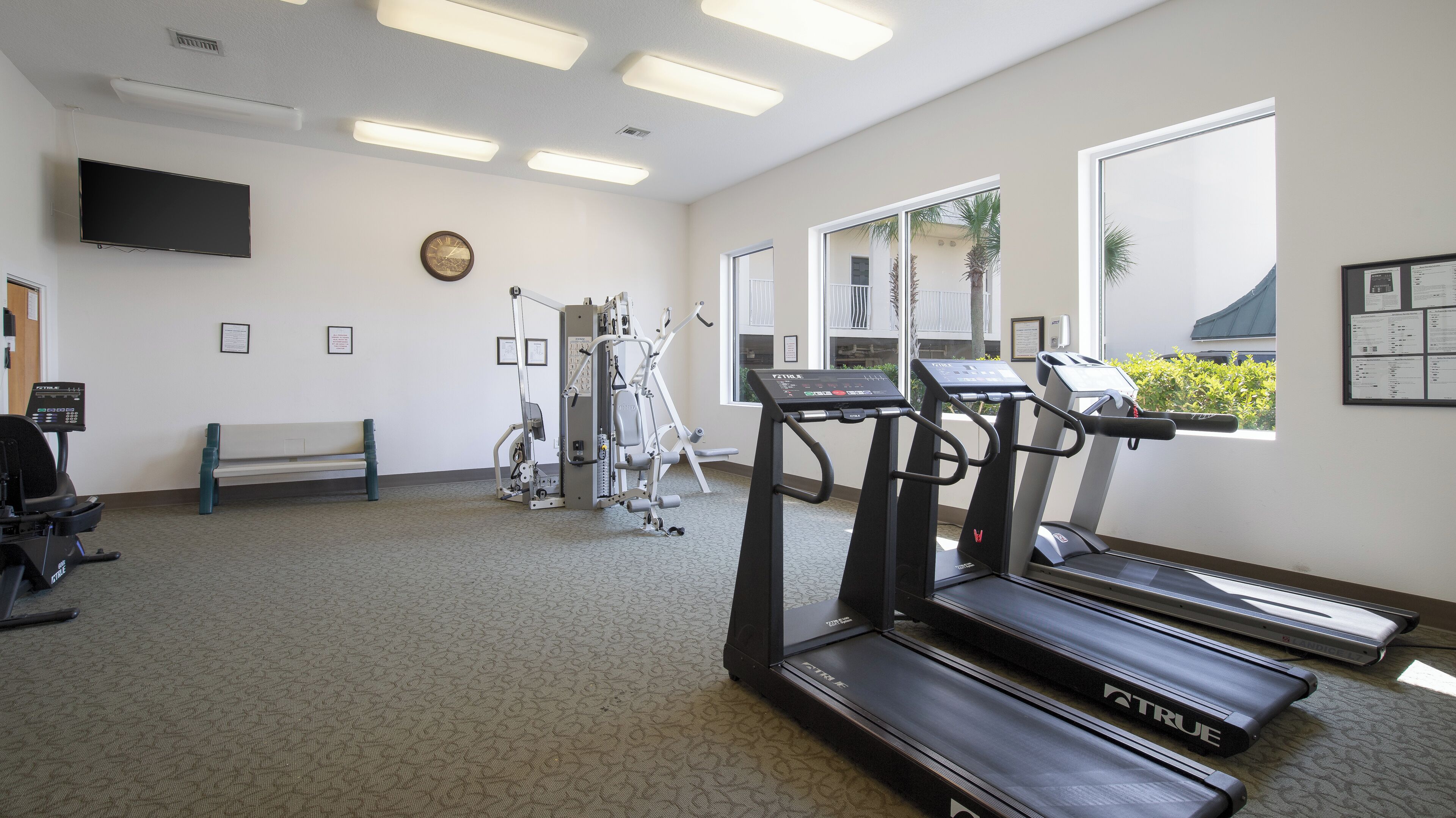 A fitness center with treadmills, a stationary bike, and a weight machine.