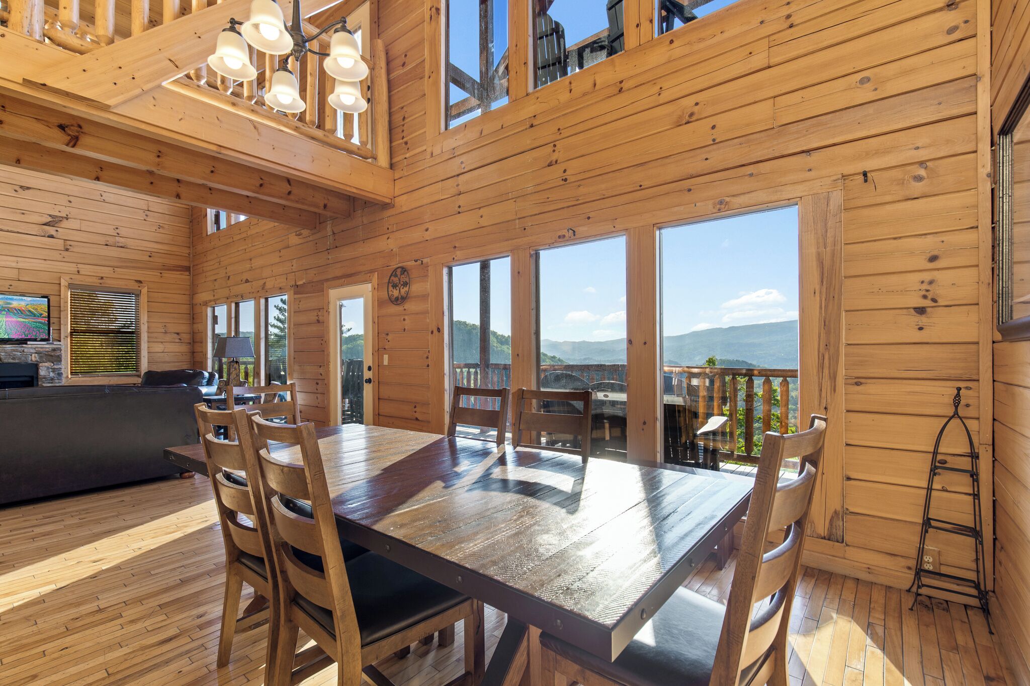 A wooden interior with a dining table, chairs, and a sofa.
