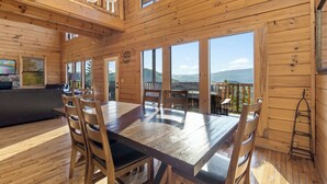 A wooden interior with a dining table, chairs, and a sofa. - Theatre in the Mountains by Jackson Mountain Rentals (Sevierville)