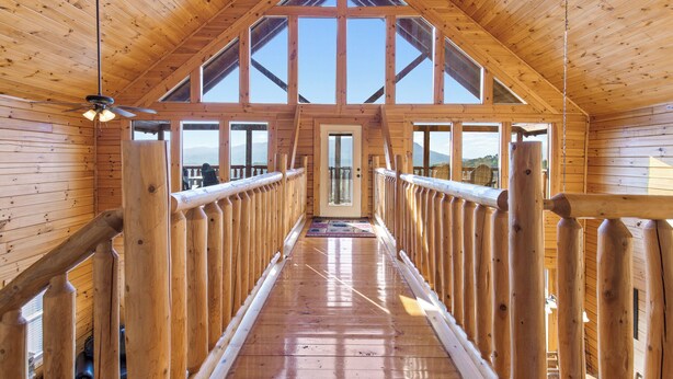 A wooden interior with a high ceiling, large windows, and a central door leading to an outdoor area. - Theatre in the Mountains by Jackson Mountain Rentals (Sevierville)