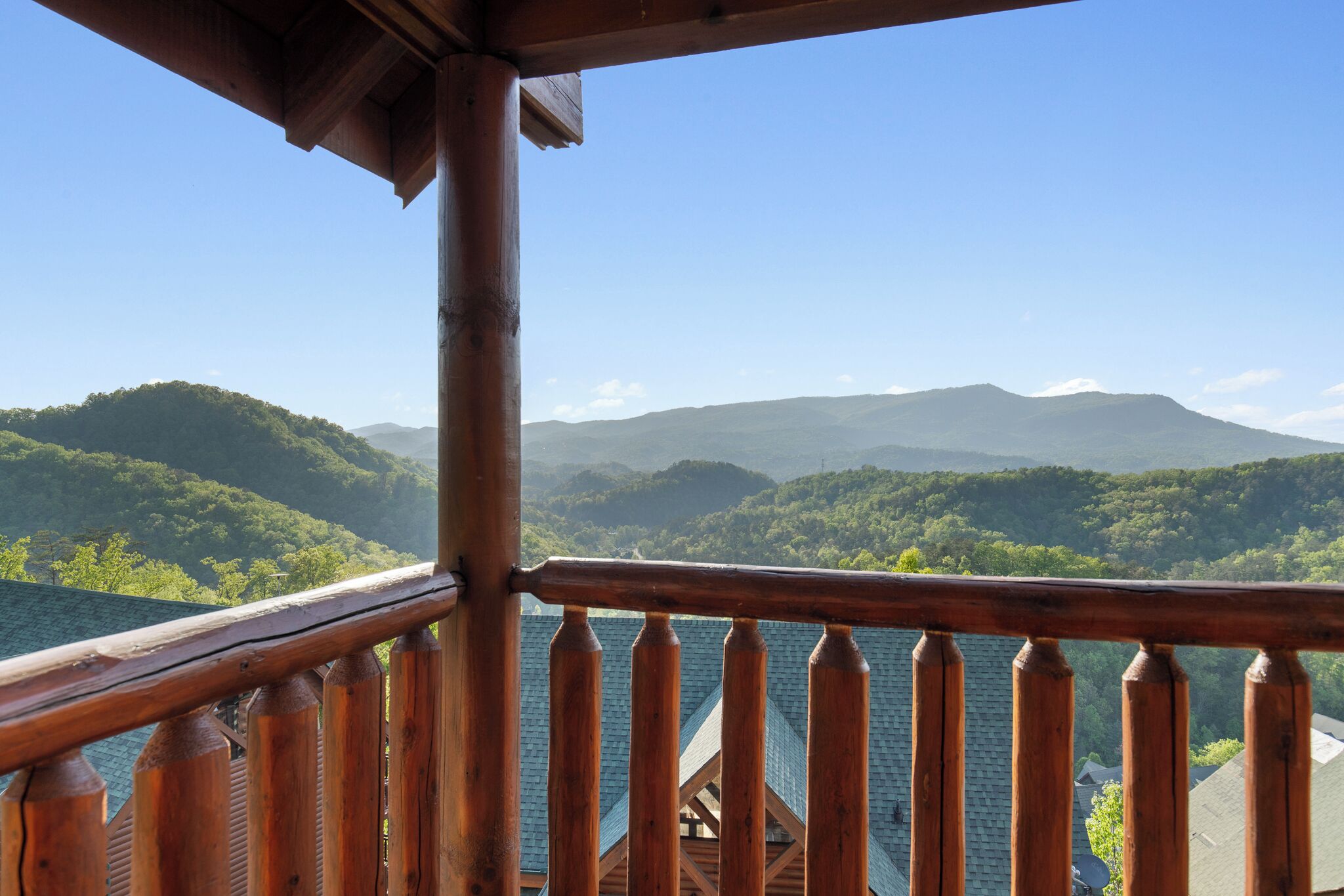 Uma varanda de madeira com vista para uma paisagem montanhosa.