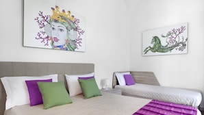 Habitación de hotel con dos camas, cada una con cabecero, y un cuadro grande sobre ellas.