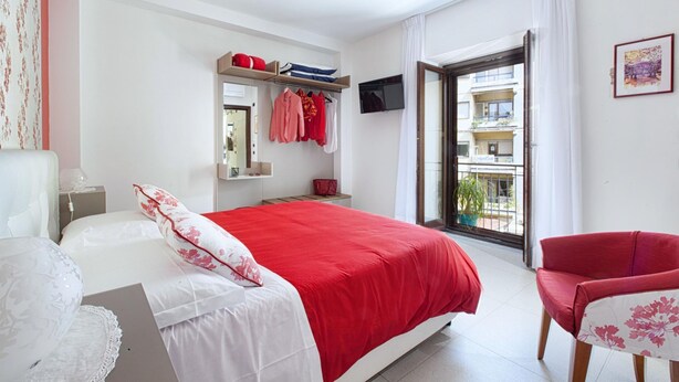A bedroom with a bed, a chair, a TV, and a balcony. - Casa Cristina Yellow (Sorrento)