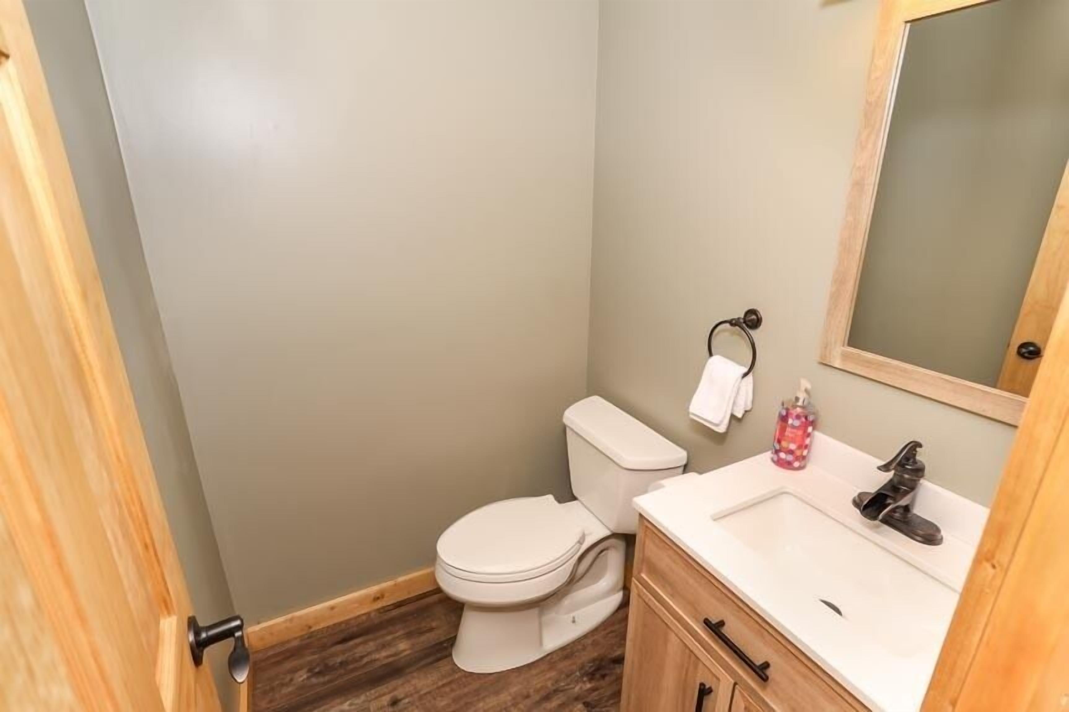 Une petite salle de bain avec des toilettes, un lavabo et un miroir.