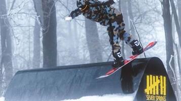 A snowboarder performing a trick on a rail.