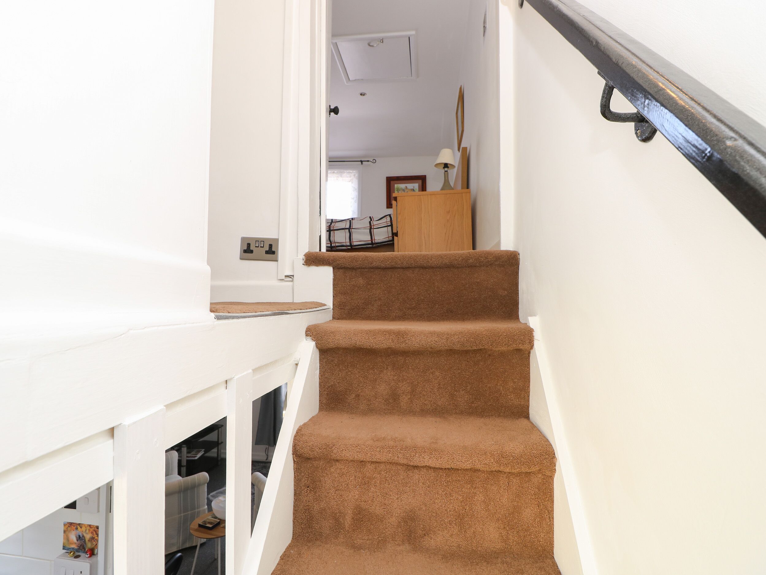 Eine Treppe mit Teppichstufen, die zu einer Zwischenebene führt.